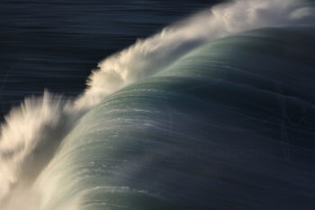Breaking blue ocean wave in Sydney, Australia, captured with motion blur as abstract fine art seascape photography