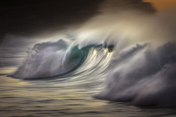 Breaking ocean wave glowing at sunrise at Bronte Beach, Sydney, Australia, captured as fine art seascape photography