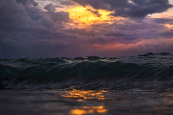 Ocean waves reflecting a fiery sunset beneath dramatic clouds at Tamarama Beach, Sydney, fine art ocean photography