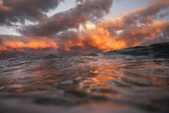 Fiery sunset clouds reflected across the ocean waves at Bondi Beach, Sydney, Australia, captured in vibrant coastal photography
