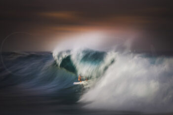 Surfer riding inside a breaking wave at sunset at Bronte Beach, Sydney, captured in dramatic ocean photography.