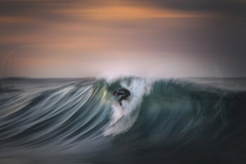 Surfer carving across a breaking wave at sunset at Bronte Beach, Sydney, captured in fine art surf photography.