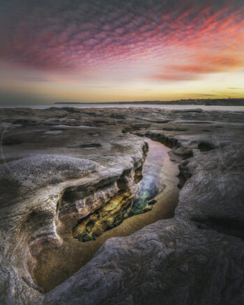Rock platform and tidal pool beneath a colourful sunset sky at Bondi Beach, Sydney, Australia, fine art coastal photography.
