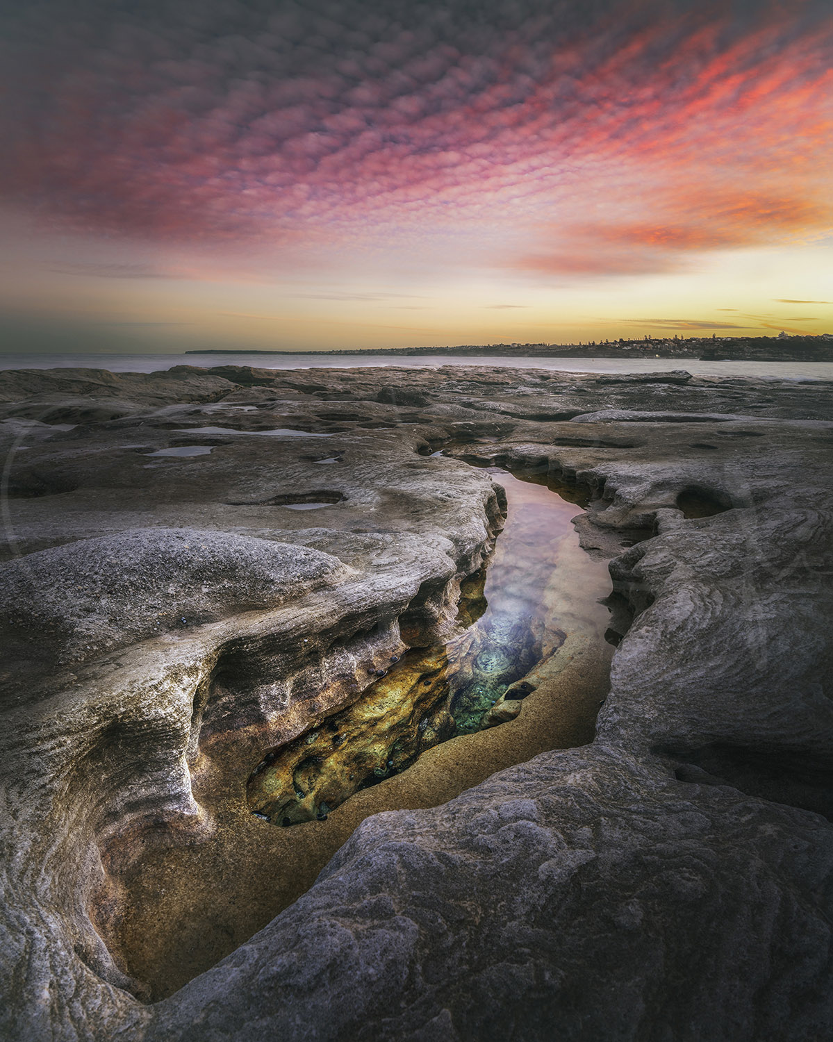 Rock platform and tidal pool beneath a colourful sunset sky at Bondi Beach, Sydney, Australia, fine art coastal photography.