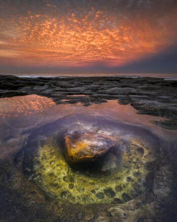 Tamarama Beach rock pool reflecting a fiery sunset sky in Sydney, Australia, captured as fine art seascape photography.