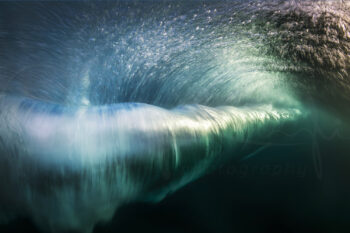Underwater wave vortex captured in Sydney, Australia, with swirling turquoise water and light beneath the ocean surface