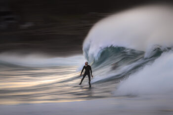Surfer riding a powerful wave at Bronte Beach, Sydney, Australia, on a crisp winter morning.