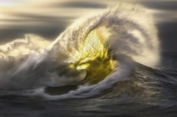 Breaking ocean wave glowing in golden sunrise light on the South Coast of New South Wales, fine art seascape photography