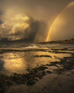 Limited edition fine art print of a sunrise rainbow over Tamarama Beach, framed by golden clouds – "Triumph of the Sun"
