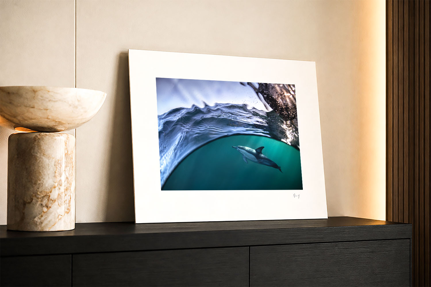 Mounted fine art print of a common dolphin swimming beneath the ocean surface, displayed as wall art in a modern interior.