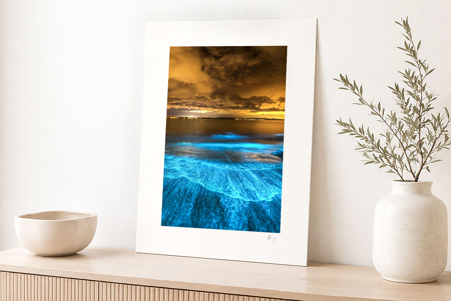 Mounted fine art print of Jervis Bay bioluminescence displayed as vibrant coastal wall art in a bright modern interior.