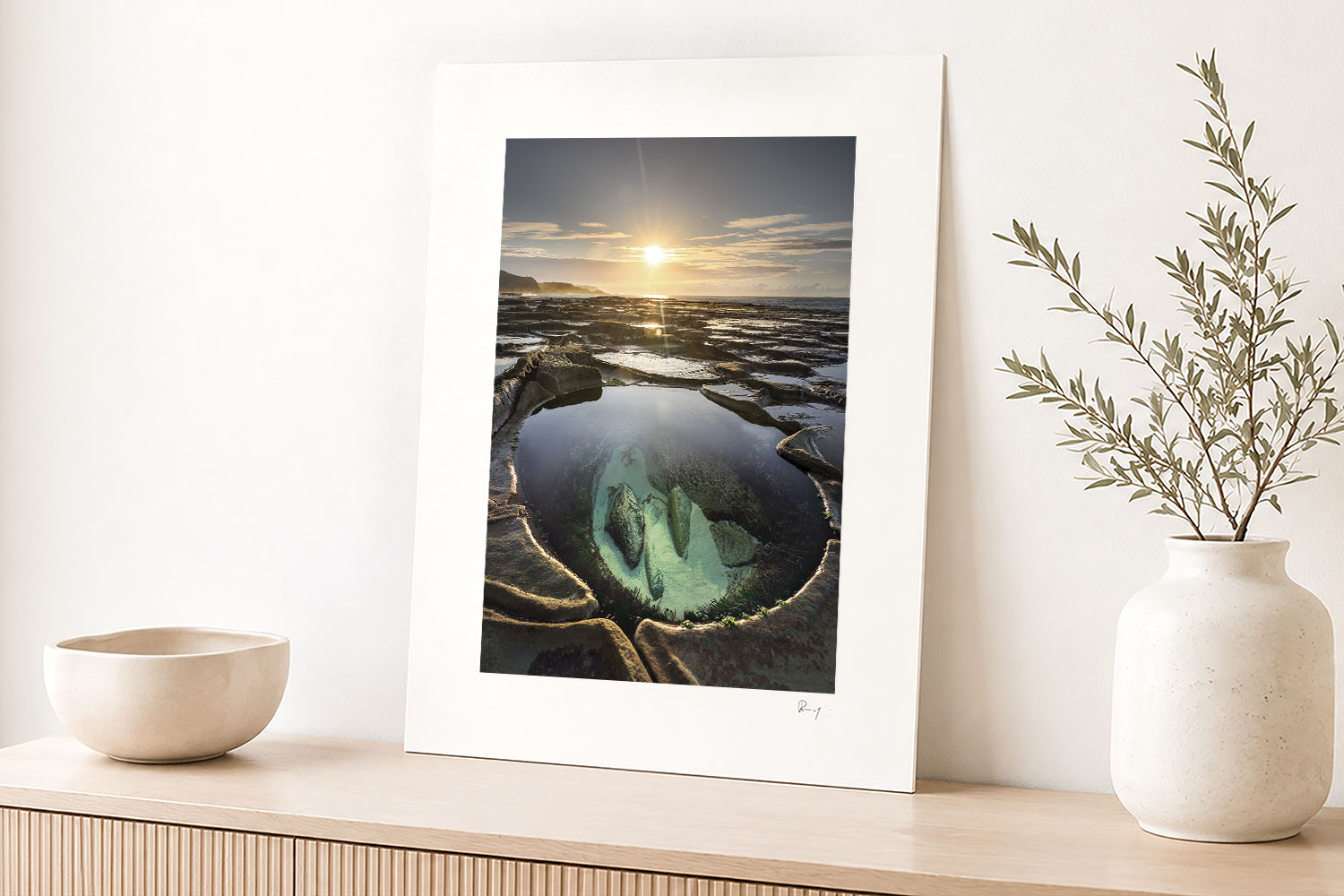 Mounted fine art print of Figure Eight Pools at sunrise displayed as coastal wall art in a bright modern interior.