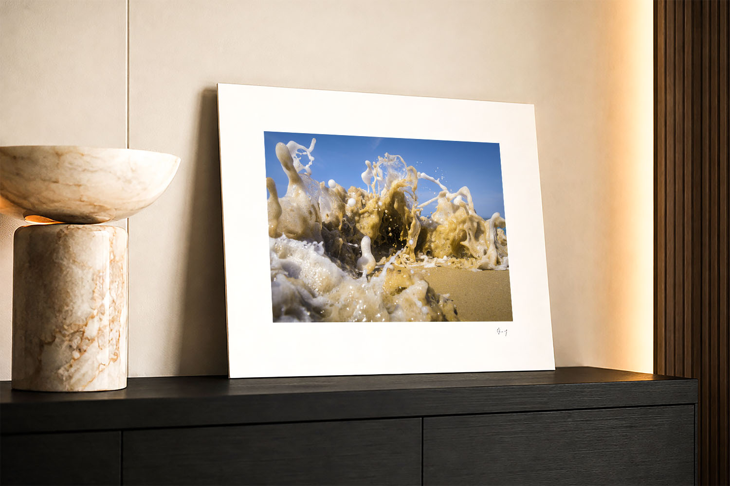 Mounted fine art print of an abstract beach wave and sculptural sea foam, displayed as coastal wall art in a modern interior.