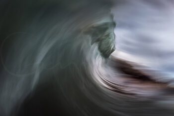 Award-winning underwater photograph of a powerful curling wave at sunrise, capturing sweeping motion and dramatic ocean textures.