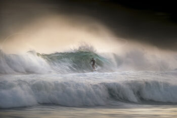 Surfer riding inside a breaking wave at sunset at Bondi Beach, Sydney, captured in fine art surf photography.