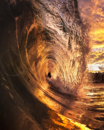 Powerful ocean wave glowing with sunset light at Bronte Beach, Sydney, Australia, captured from inside the breaking barrel