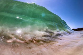 Emerald green ocean wave breaking over a sandy seabed in clear water at Jervis Bay, Australia, coastal fine art photography