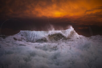 Breaking ocean wave beneath a fiery sunset at Bronte Beach, Sydney, Australia, captured in fine art ocean photography.