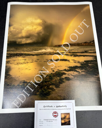 Fine art print of a golden sunrise and vivid rainbow over Tamarama Beach, with dramatic storm clouds and glowing reflections.