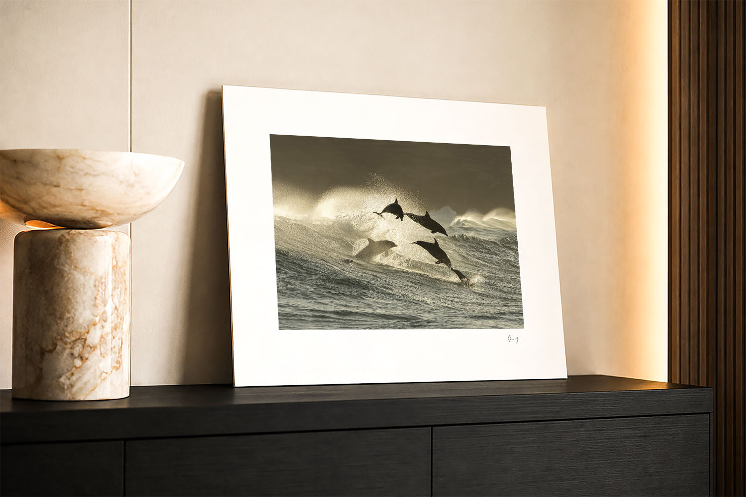 Mounted fine art photograph of bottlenose dolphins leaping through waves at Bronte Beach at sunrise in dramatic golden light.