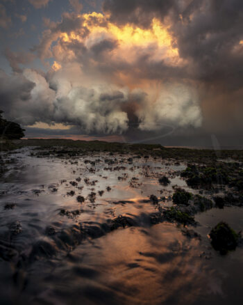 Stormy sunset over the rocky coastline and tidal pools at Tamarama Beach, Sydney, Australia, fine art seascape photography.
