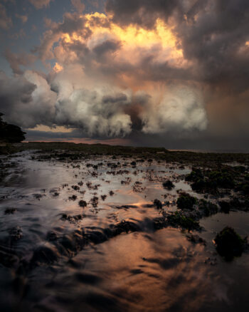 Award-winning fine art ocean print of storm clouds glowing at sunset with tidal reflections at Tamarama Beach, Sydney – "Stygian Seas"