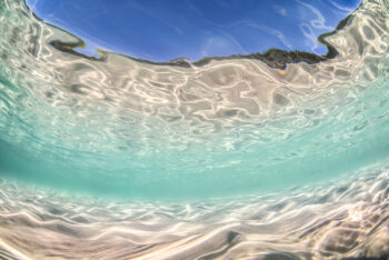 Mounted fine art print of shimmering turquoise shallows at Jervis Bay, Australia, where sunlight dances across rippled sand and water.