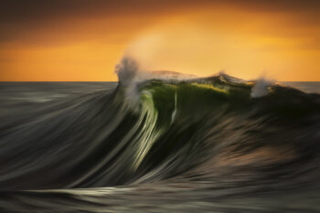 Powerful green sunrise wave curling under warm sky on the South Coast of New South Wales.