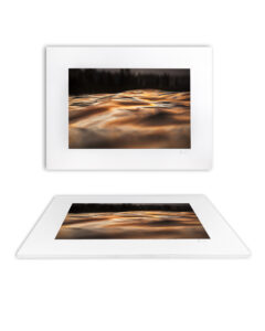 Golden sunset ripples on calm ocean water at Bondi Beach, Sydney, with warm light reflecting across gentle waves.