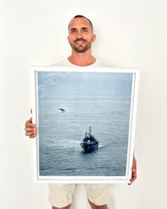 Breaching humpback whale beside the Sea Shepherd ship Steve Irwin off Byron Bay, Australia, captured from the coastline.