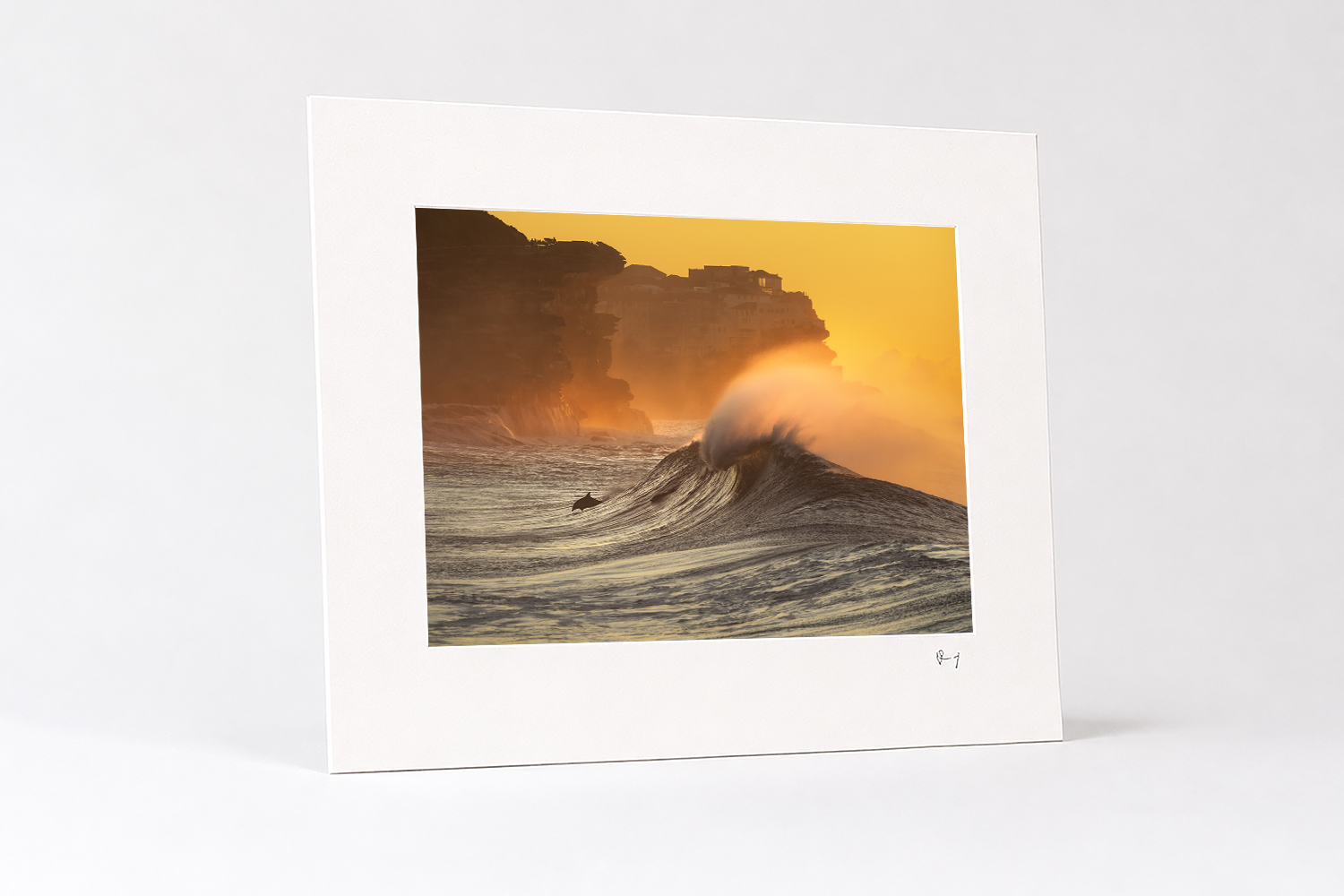 Mounted fine art photography print of a dolphin swimming through a golden sunrise wave at Bronte Beach, Sydney.