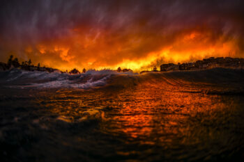 Award-winning fine art photograph of a fiery sunset reflected across the ocean at Bronte Beach, Sydney, Australia.