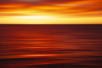 Abstract ocean sunrise at Bondi Beach, Sydney, with vivid red, orange and golden light reflected across the moving sea.