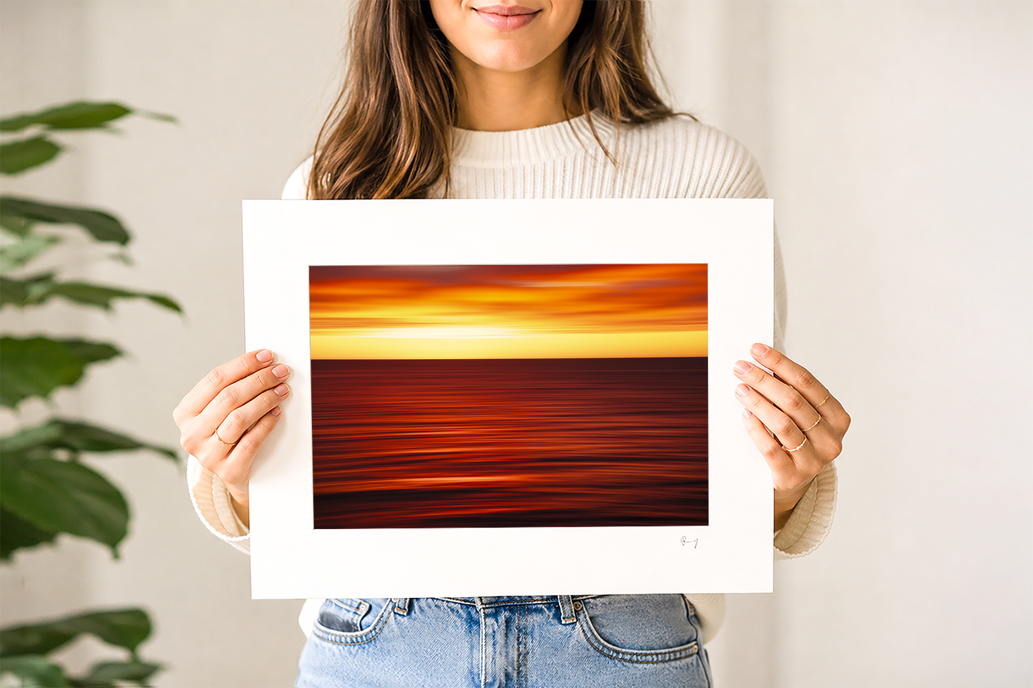 Woman holding a mounted fine art print of an abstract ocean sunrise captured at Bondi Beach, Sydney.