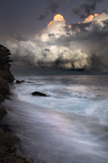 Mounted fine art print of storm clouds above the ocean at Tamarama Beach, Sydney, Australia, presented with a white mat board.