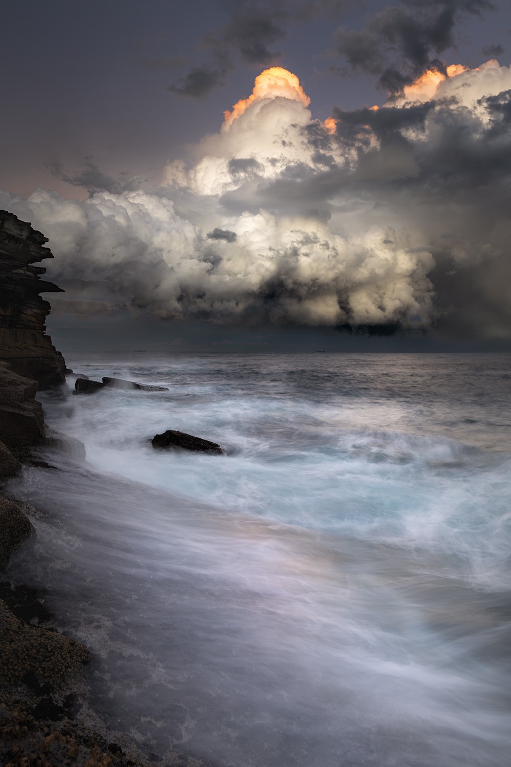 Mounted fine art print of storm clouds above the ocean at Tamarama Beach, Sydney, Australia, presented with a white mat board.